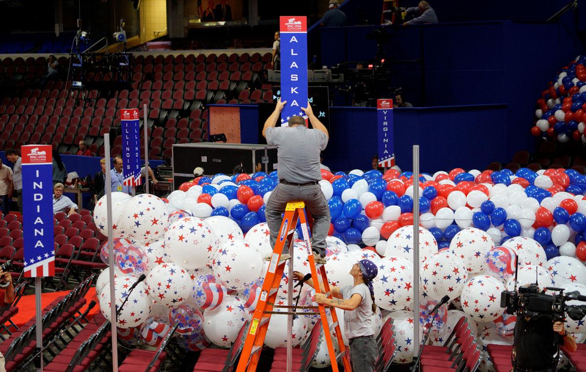 A worker installs the sign for the Alaska delegation near RNC balloons.