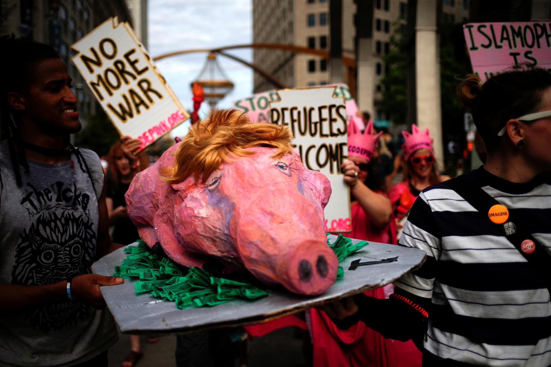 Activists carry a prop during a protest march by various groups, including 