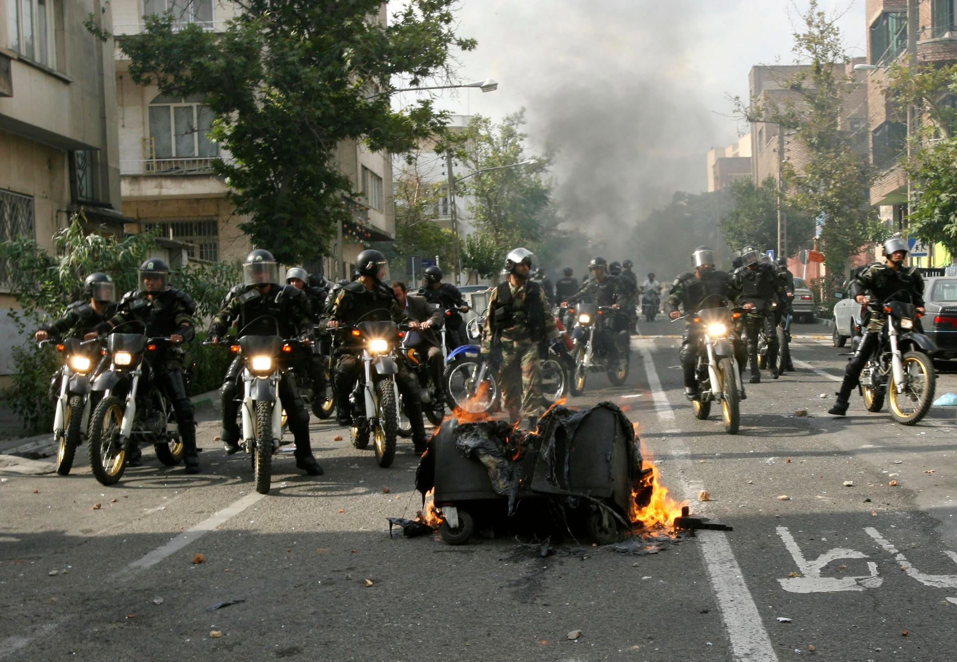 IRAN-ELECTION/RTR24VNP21 Jun. 2009Tehran, Iran Iranian security personnel ride past burning debris on the streets in Tehran June 20, 2009.
