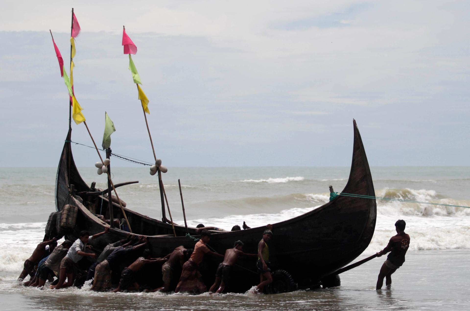 Rohingya fishermen pull a boat near a refugee camp in Cox's Bazar, Aug. 19, 2011.