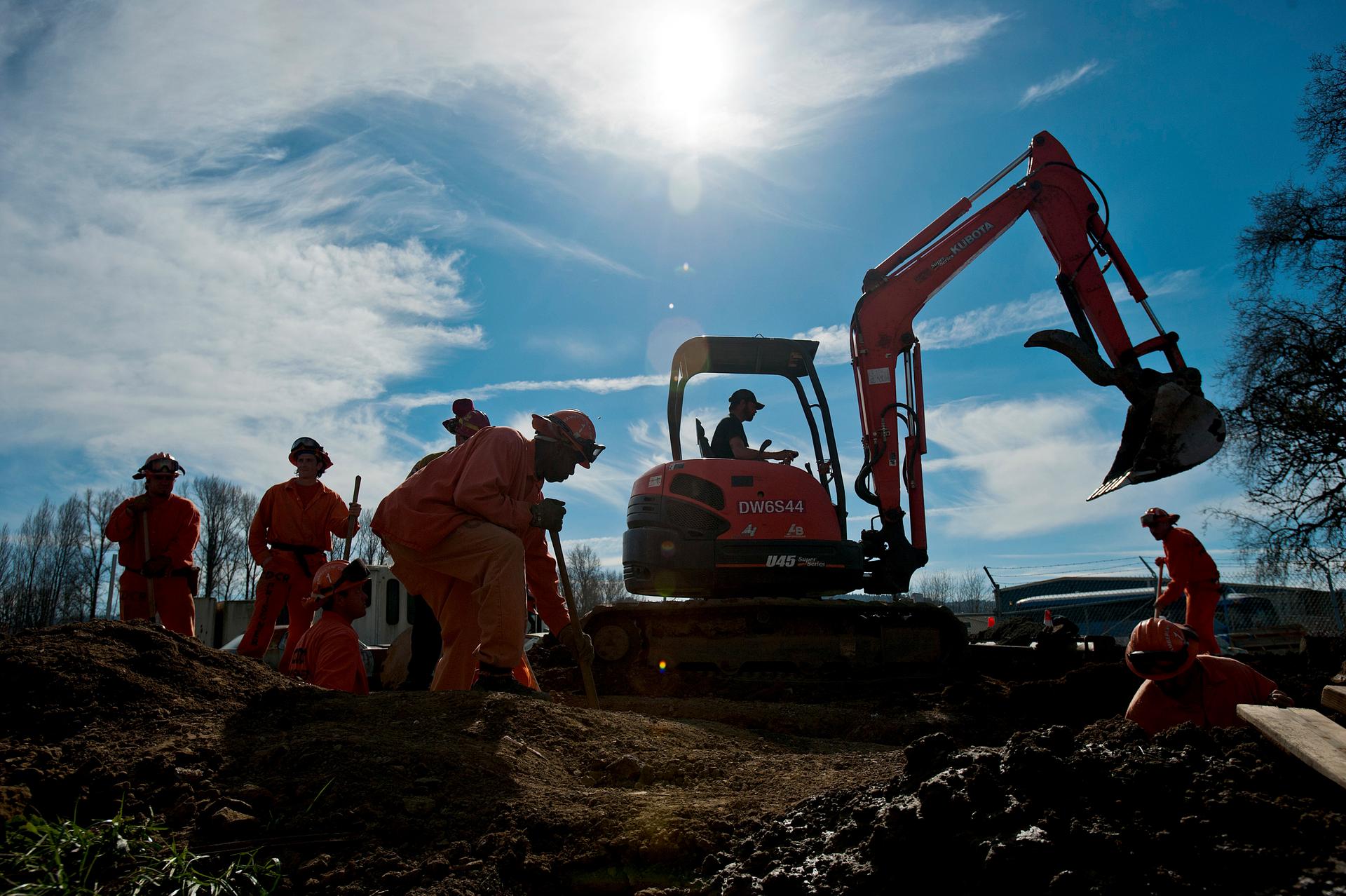 Prison laborers and an excavator operator help construct an emergency pipeline to increase supplies of potable water in Willits, California February 25, 2014.