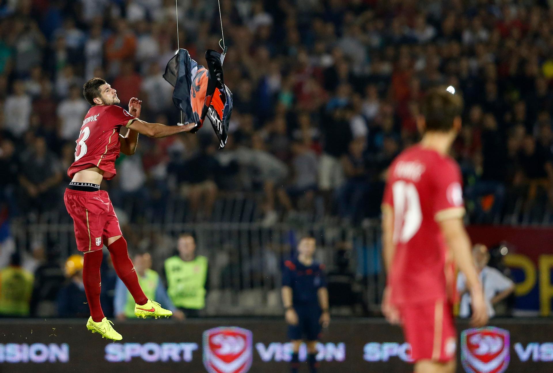 Stefan Mitrovic of Serbia grabs a flag depicting so-called 