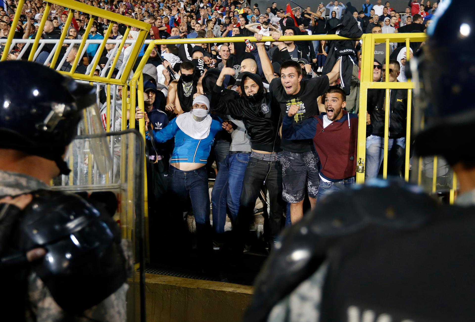Fans of Serbia confront the riot police during the Euro 2016 Group I qualifying soccer match between Serbia and Albania at the FK Partizan stadium in Belgrade on October 14, 2014.