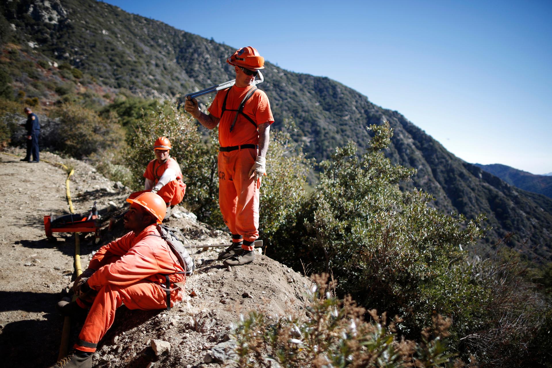 Prison inmates lay water pipe on a work project outside Oak Glen Conservation Fire Camp #35 in Yucaipa, California November 6, 2014.