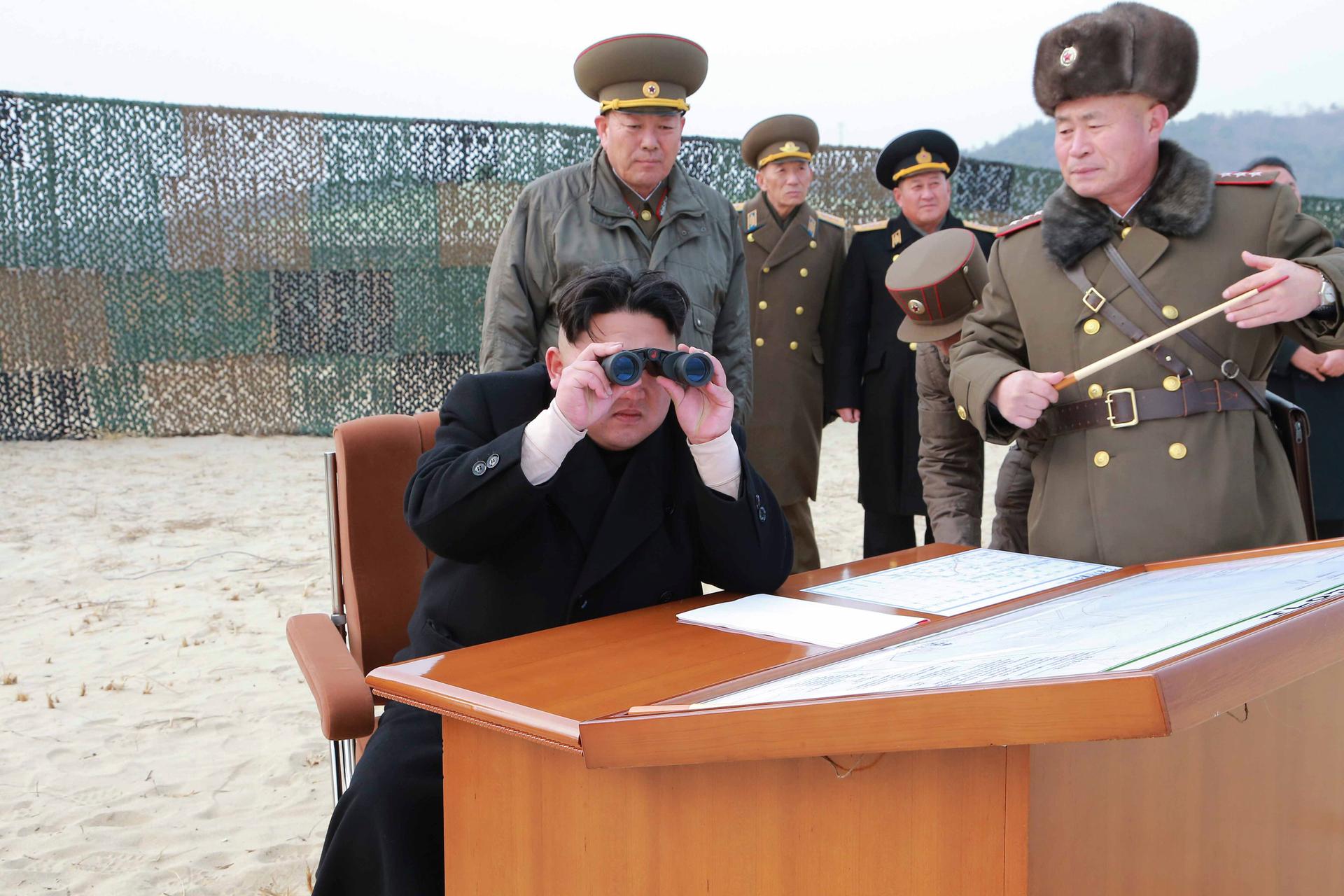 North Korean leader Kim Jong Un looks through a pair of binoculars as he guides the multiple-rocket launching drill of women's sub-units under KPA Unit 851, in this undated photo released by North Korea's Korean Central News Agency.