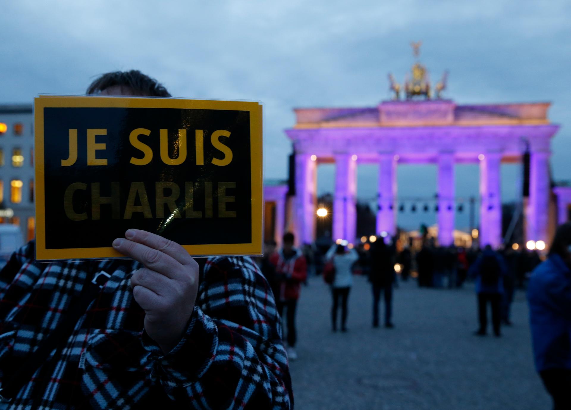 A placard is waved at a demonstration in Berlin on Tuesday night organized by Muslim groups to commemorate those killed in the French attacks.