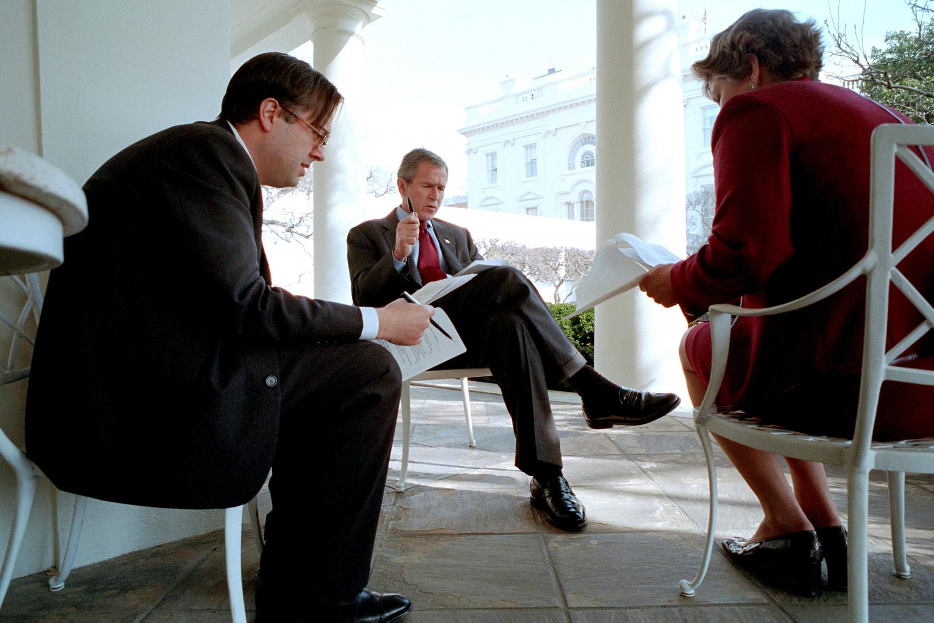 Three people sitting in chairs outside Oval Office