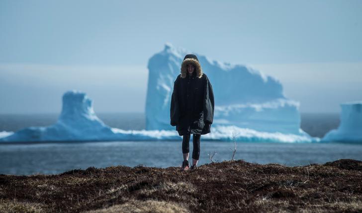 A resident views the first iceberg of the season as it passes the South Shore near Ferryland Newfoundland, Canada.