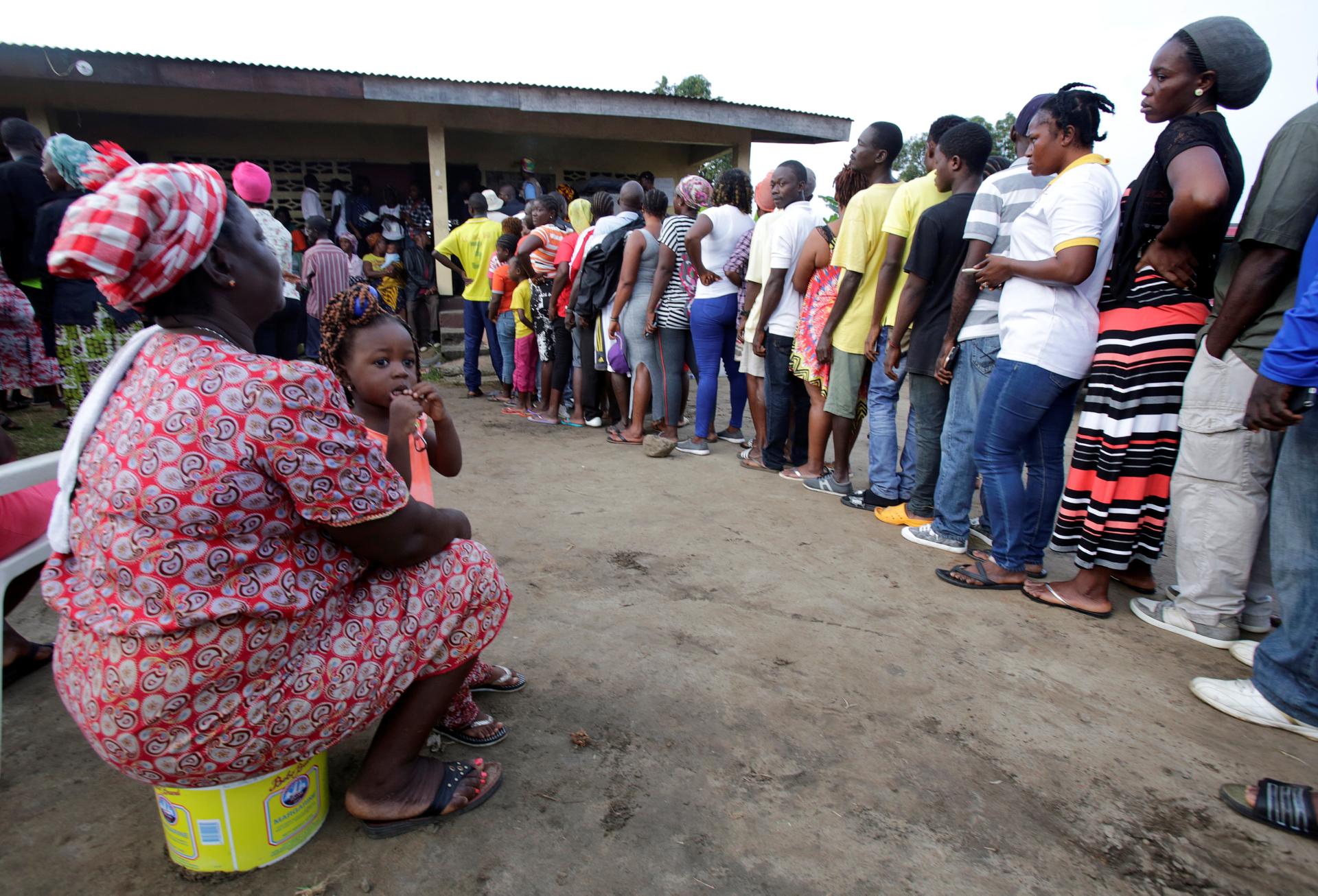 People wait to vote during the presidential election at a polling station of Duport Road in Monrovia, Liberia, Oct. 10, 2017. 