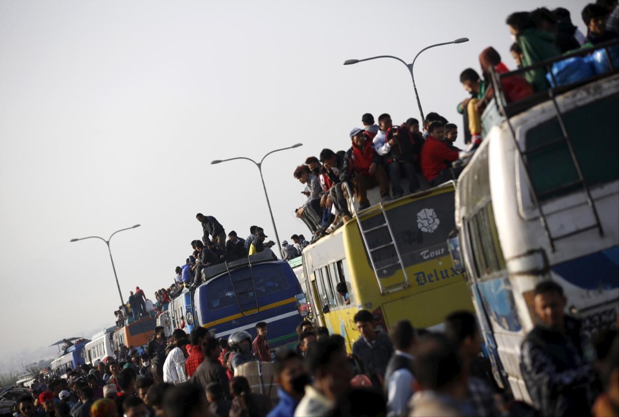Passengers ride inside and atop overcrowded buses as they head toward their village to celebrate a Hindu festival in Nepal in October 2015.