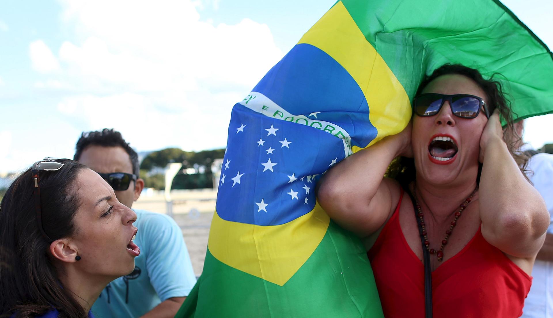 An anti-government demonstrator (L) shouts slogans against a supporter of Brazil's President Dilma Rousseff during a protest against the appointment of former President Luiz Inacio Lula da Silva as a minister, in front of the Planalto Palace in Brasilia,