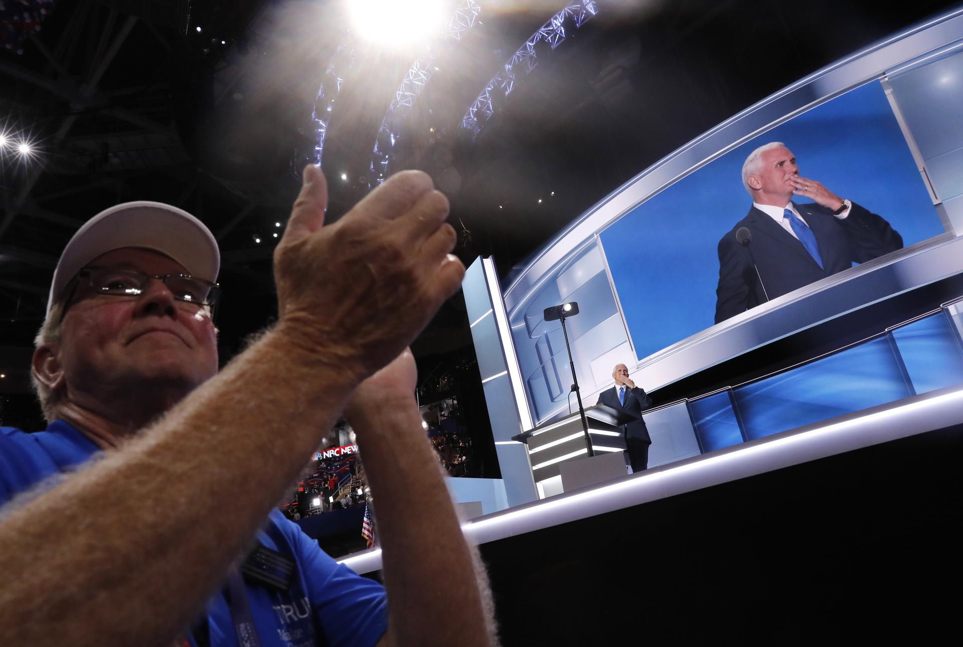 A delegate applauds as Republican vice presidential nominee Indiana Governor Mike Pence speaks during the third night at the Republican National Convention in Cleveland, Ohio, U.S. July 20, 2016.