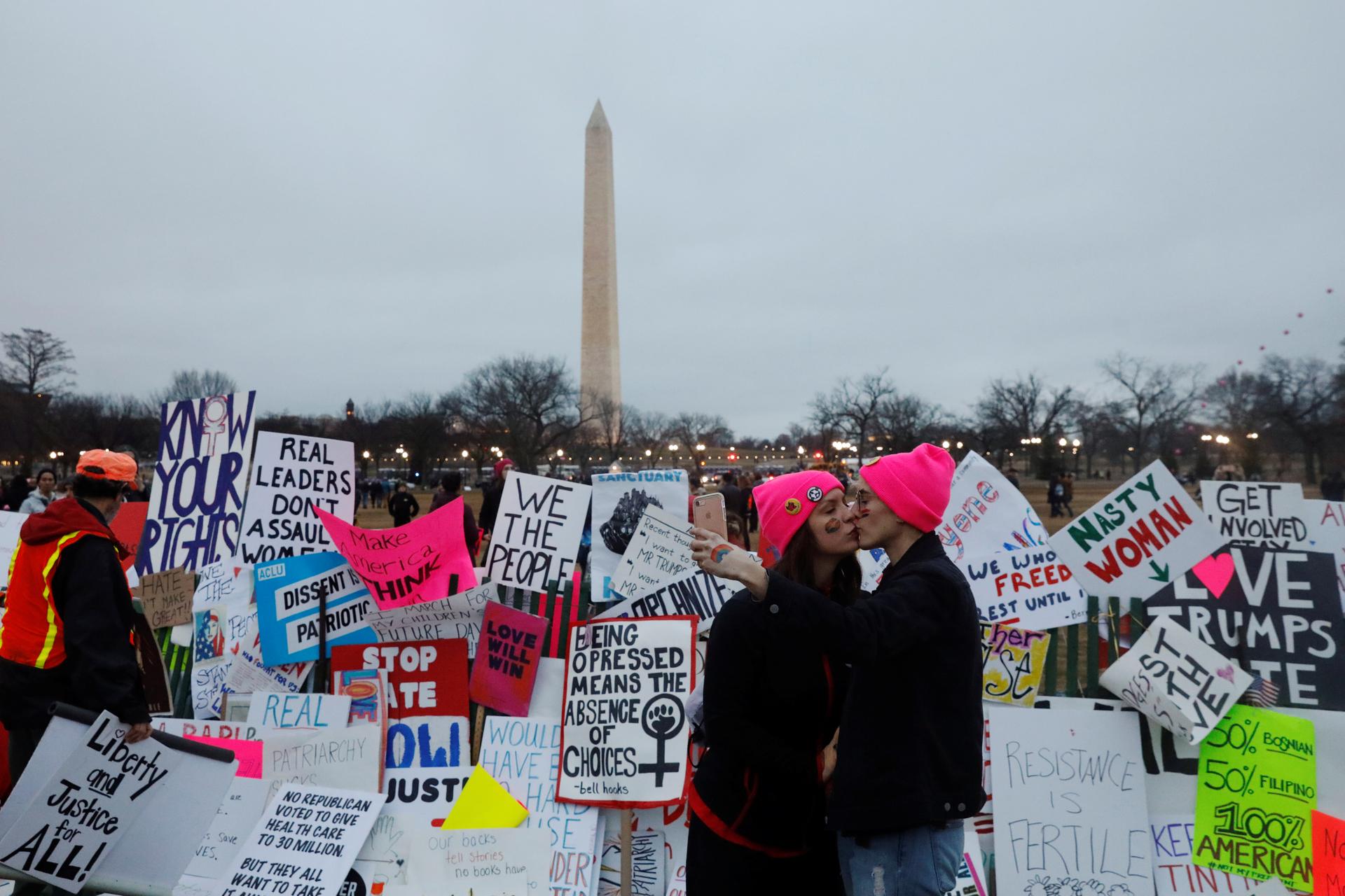 A same sex couple kisses in front of a wall of protest signs while taking part in the Women's March to protest Donald Trump's inauguration as the 45th president of the United States close to the White House in Washington, January 21, 2017.