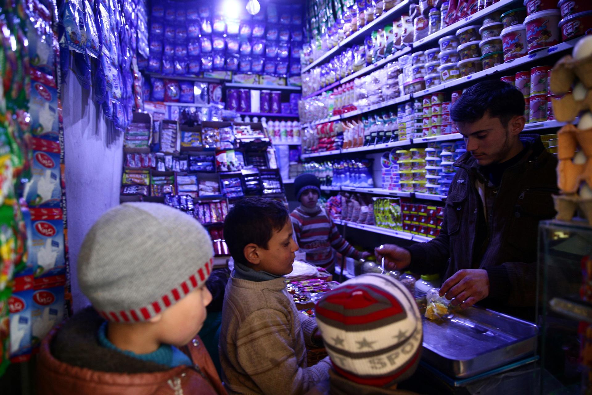 Boys buy goods from a grocery shop in the rebel-held, besieged Damascus suburb of Eastern Ghouta, Syria, Feb. 12, 2017.