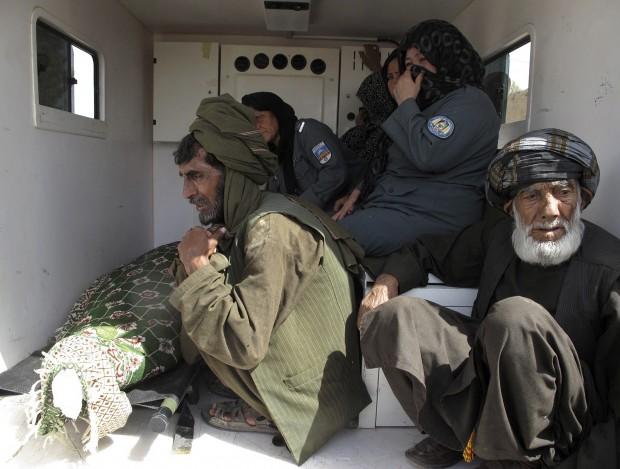 Relatives and policewomen sit at the back of an ambulance as they transport the body of Sub-Inspector Negara for burial in Helmand province. (Photo: REUTERS/Abdul Malik)