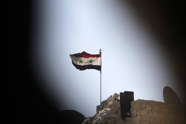 The battle for Syria continues. Here a Syrian national flag can be seen from a rebel position, flying over a building controlled by forces loyal to President Assad in Ashrafieh, Aleppo, September 17th 2013. (Photo: REUTERS/Muzaffar Salman)