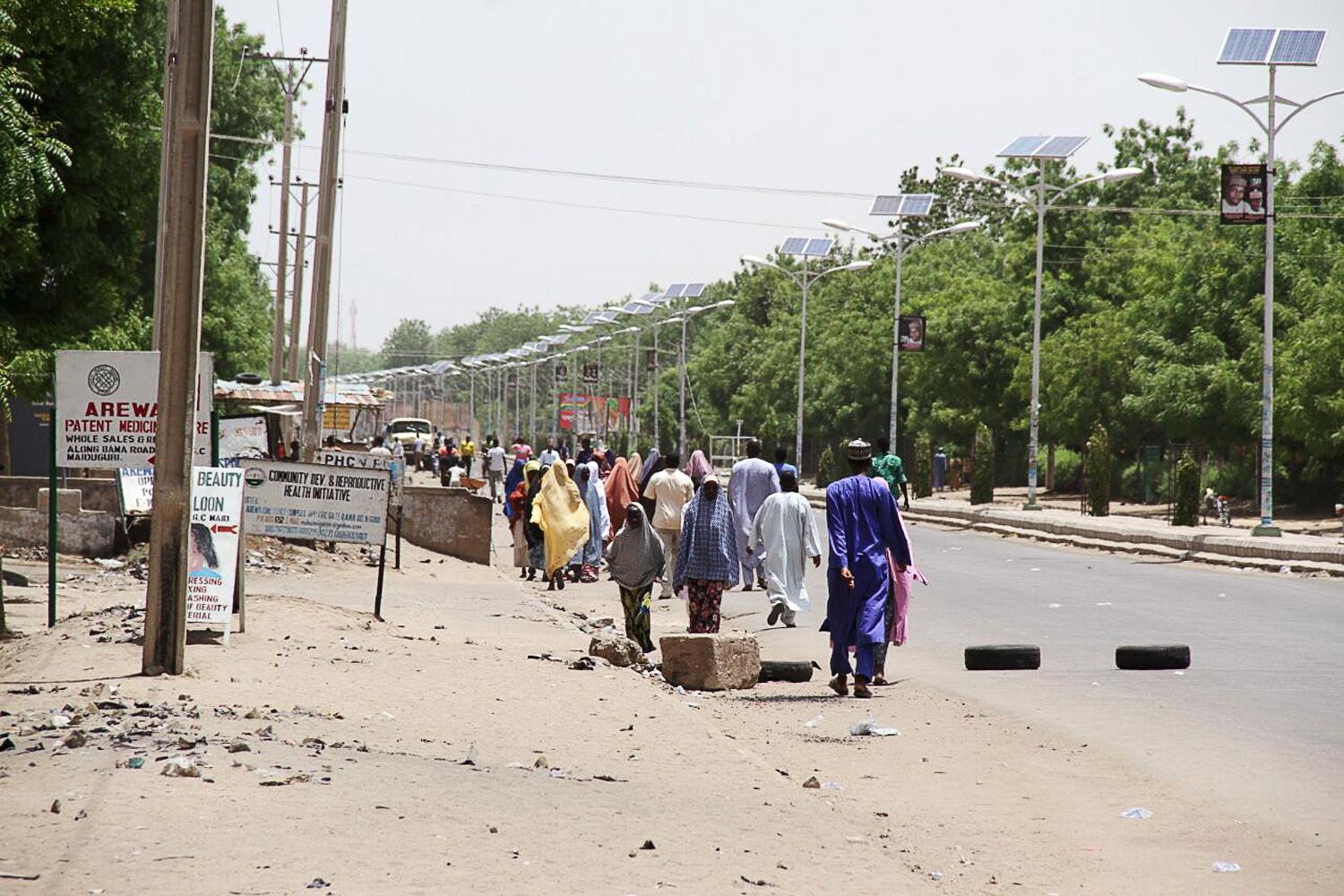 People walk along a road as they flee, in Maiduguri in Borno State, Nigeria May 14, 2015.