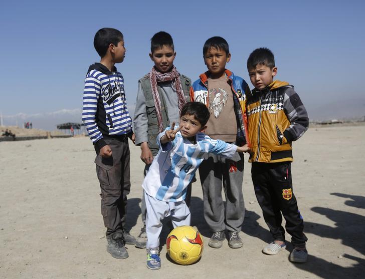 Five year-old Murtaza Ahmadi wearing a shirt signed by Barcelona star Lionel Messi, poses before playing soccer with boys at the open area in Kabul, Afghanistan.