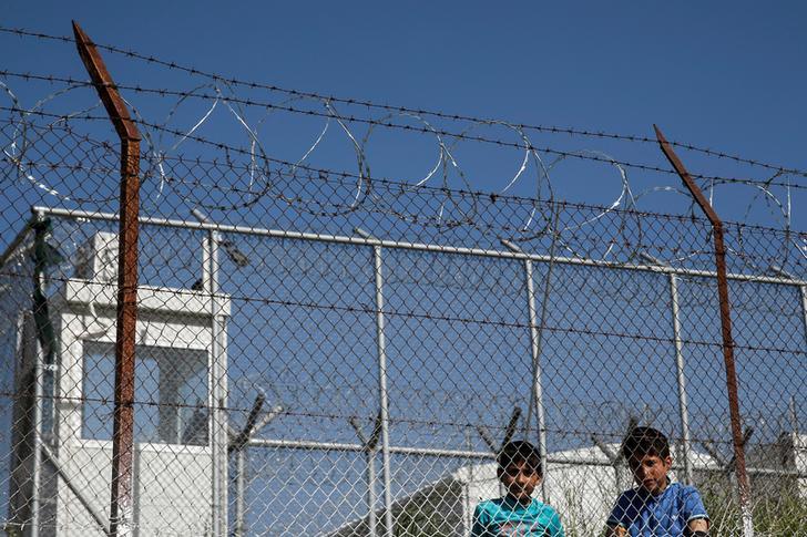 Children are seen behind a fence at the Moria holding centre for refugees and migrants, which Pope Francis will visit on April 16 on the Greek island of Lesbos.