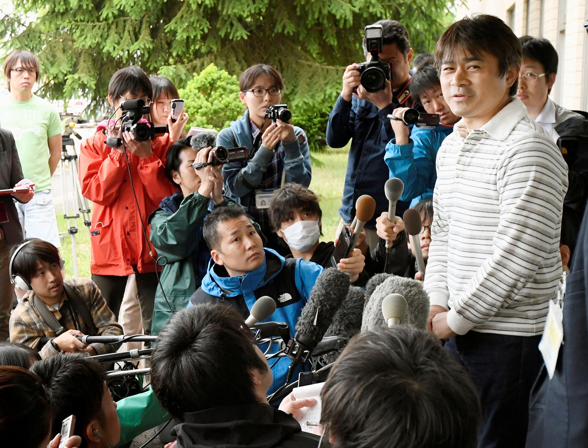 Takayuki Tanooka (R), father of 7-year-old boy Yamato Tanooka who went missing on May 28, 2016 after being left behind by his parents, was found alive, speaks to the media in Hakodate on the northernmost Japanese main island of Hokkaido, Japan, in this ph