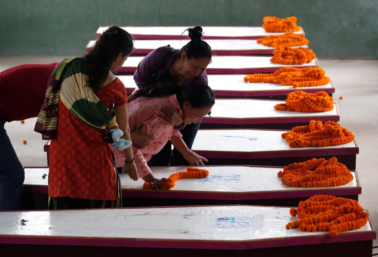 Family members of the Nepali victims killed in a bombing attack in Kabul weep over their coffins on June 22.