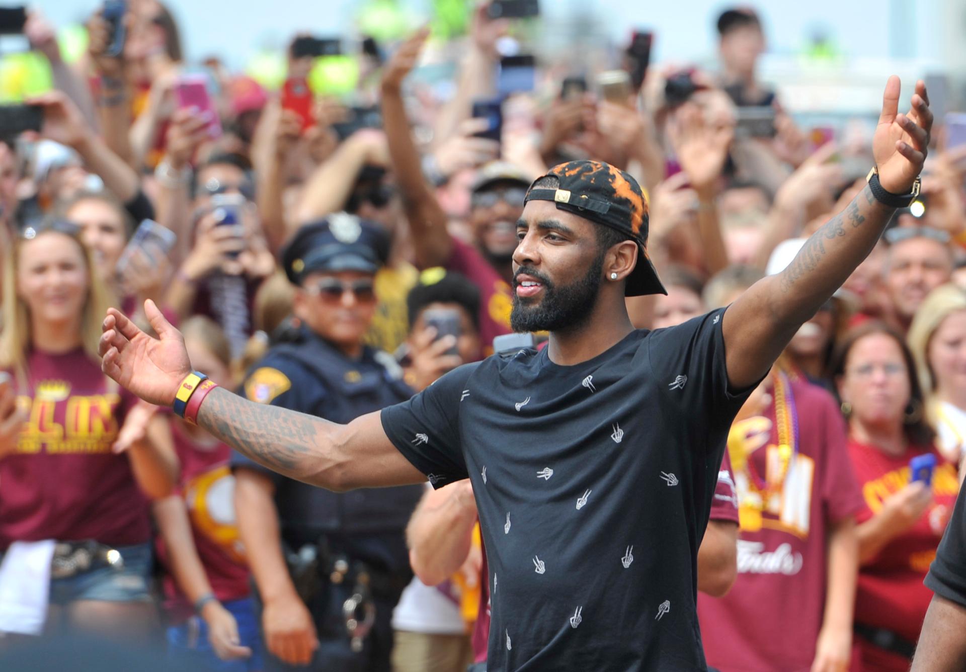 Cleveland Cavaliers guard Kyrie Irving celebrates with fans during the NBA championship parade in downtown Cleveland.