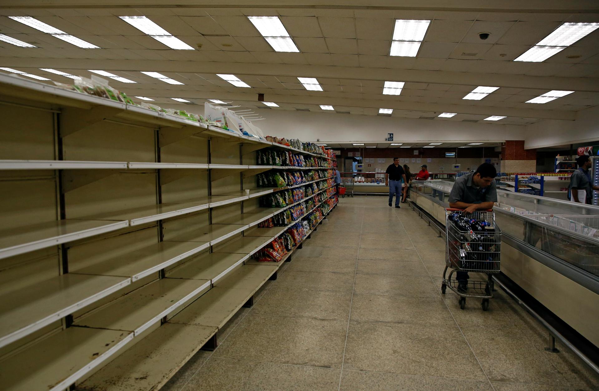 People buy food and other staple goods inside a supermarket in Caracas, Venezuela June 30, 2016.