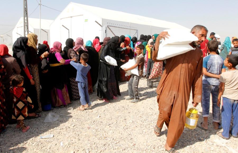 People who fled the Islamic State's strongholds of Hawija and Mosul receive aid at a camp for displaced people in Daquq, Iraq, on Oct. 13.