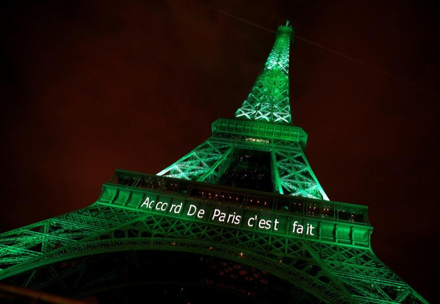 The Eiffel Tower is lit up green with the words 
