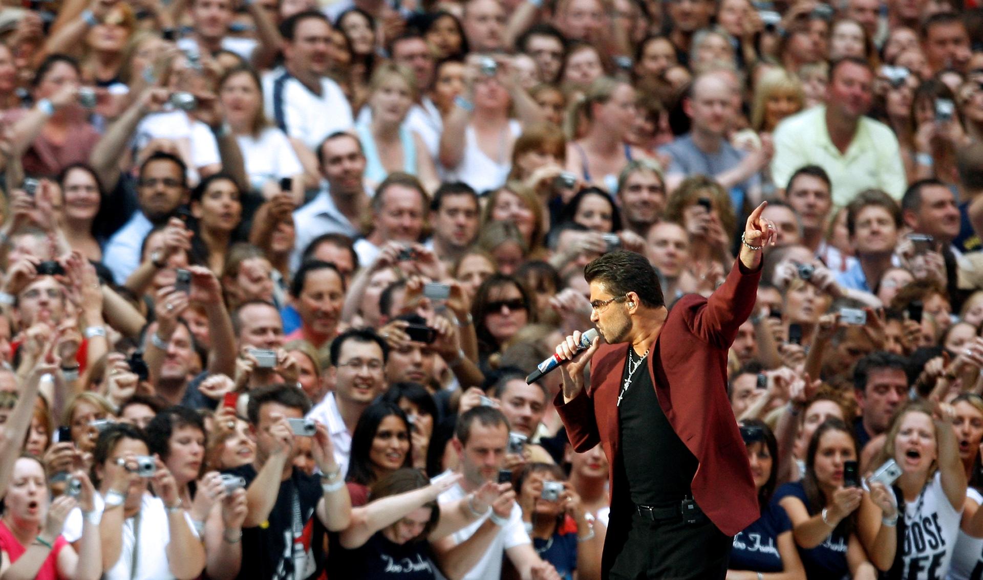 George Michael with a microphone in front of a crowd