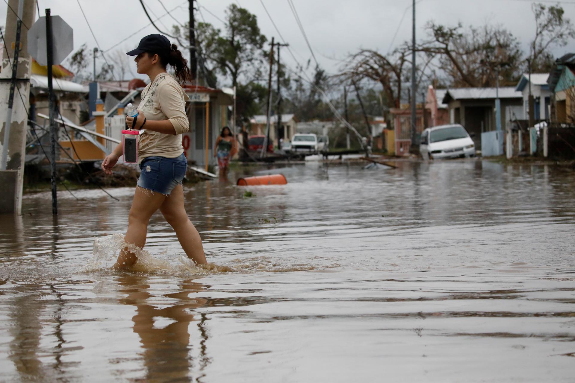 A woman wades through a flooded street after the area was hit by Hurricane Maria in Salinas, Puerto Rico, Sept. 21, 2017