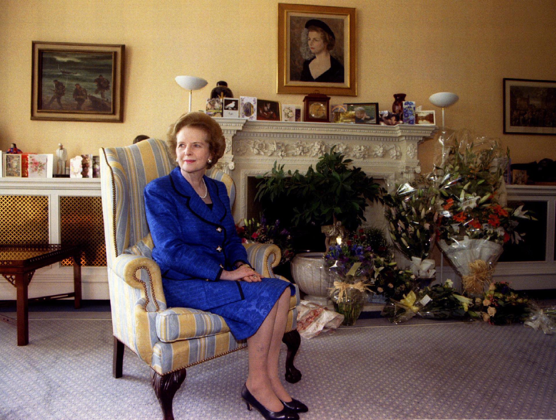 Former Prime Minister Margaret Thatcher sits at home for a 70th birthday photograph amidst floral greetings October 13, 1995.