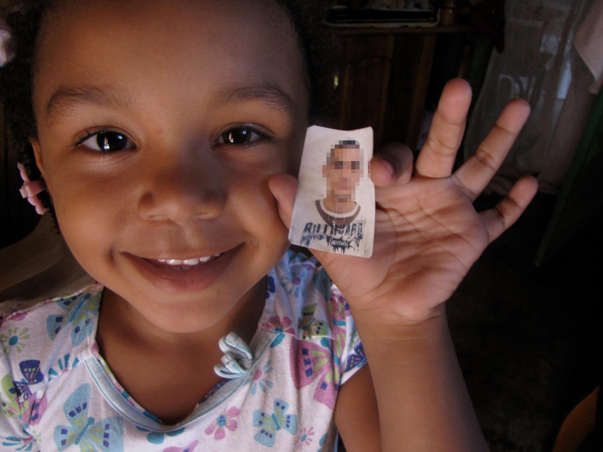 Sasha Barrios holds up a picture of the Uruguayan marine her mother says is Sasha's father. The man was a member of MINUSTAH, the UN peacekeeping for in Haiti.
