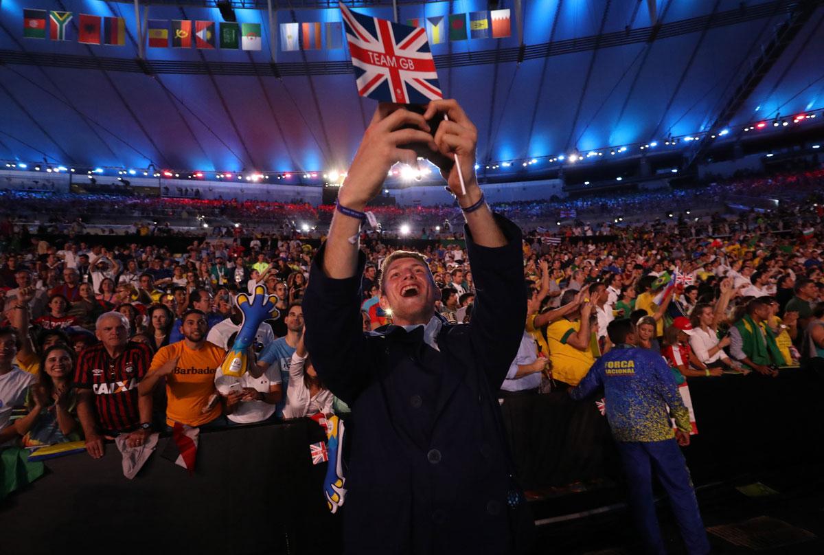 An athlete from Great Britain takes a selfie with fans during the opening ceremony.