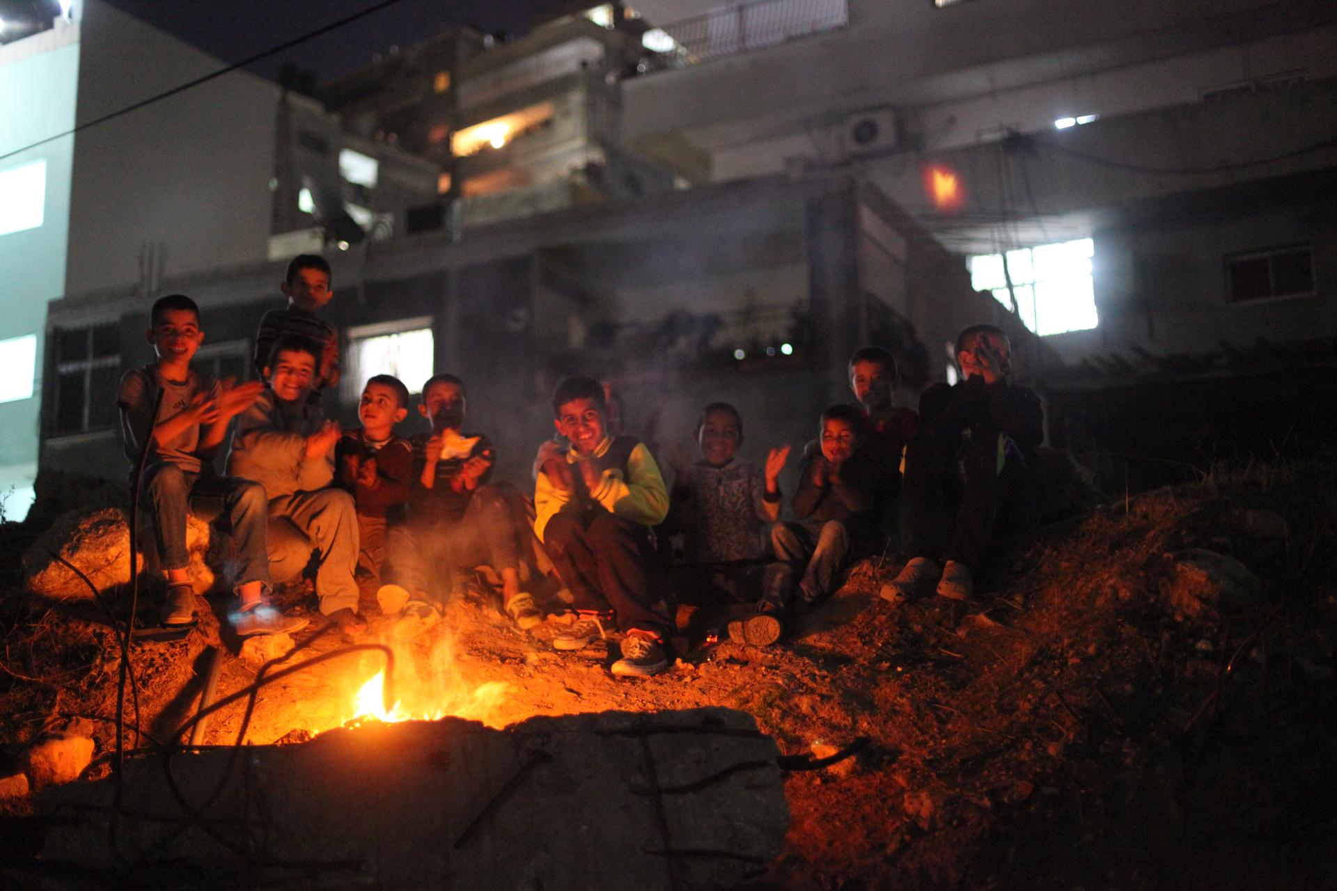 Children play by a bonfire in Shuafat refugee camp in November 2014. Activist Baha Nababta devoted his life to improving the camp, including increasing activities for youth, but he was murdered before he could carry through his plans.