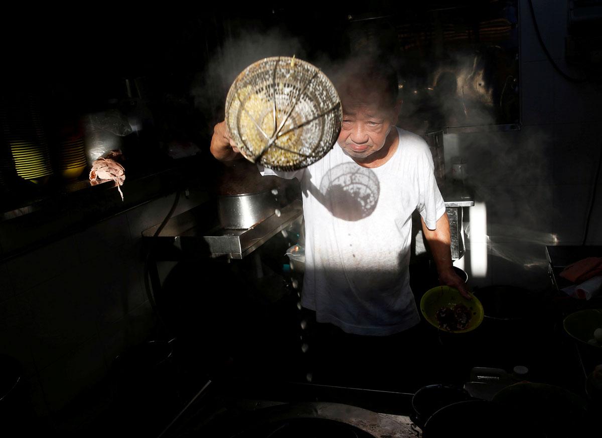 Hawker Wee Phong Sai, 66, cooks fishball noodles at his Thye Hong Handmade Fishball Noodle stall.