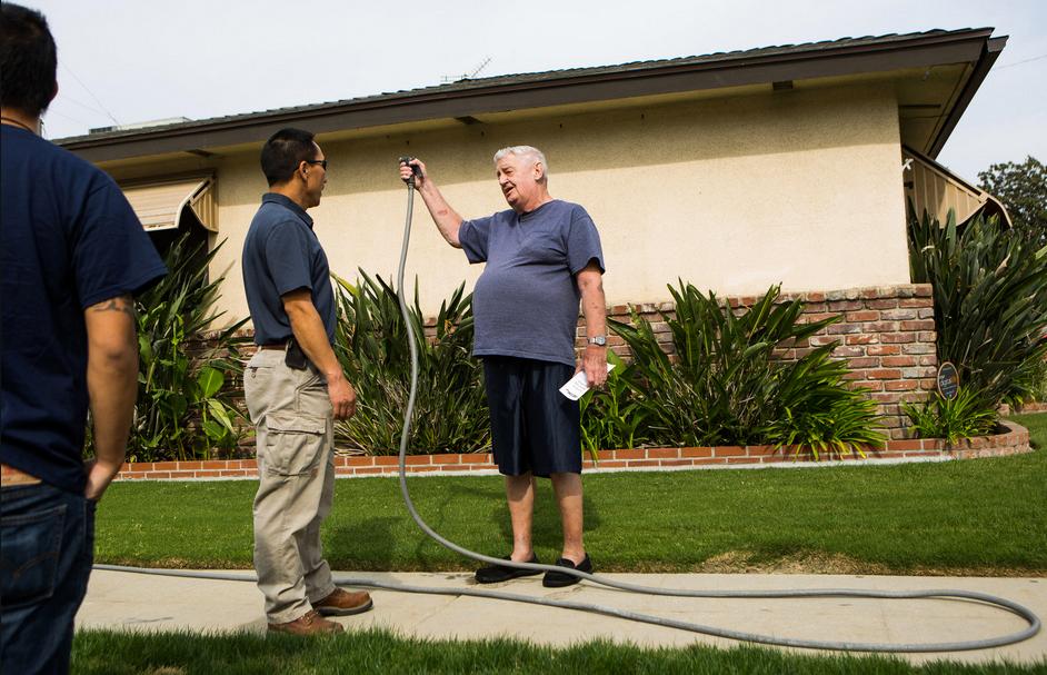 Tou Moua, left, a water conservation representative of the City of Fresno, Calif., confronted Jim Kjer after spotting him watering his lawn during the day.