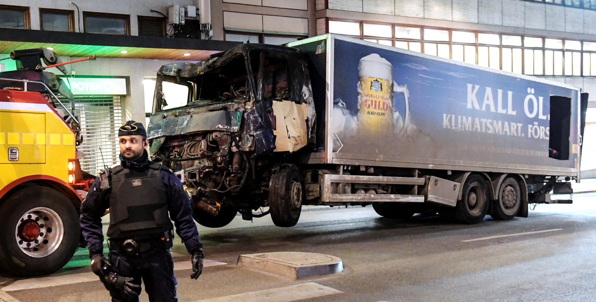 Tow trucks pull away the beer truck that crashed into the department store Ahlens after plowing down the Drottninggatan Street in central Stockholm.