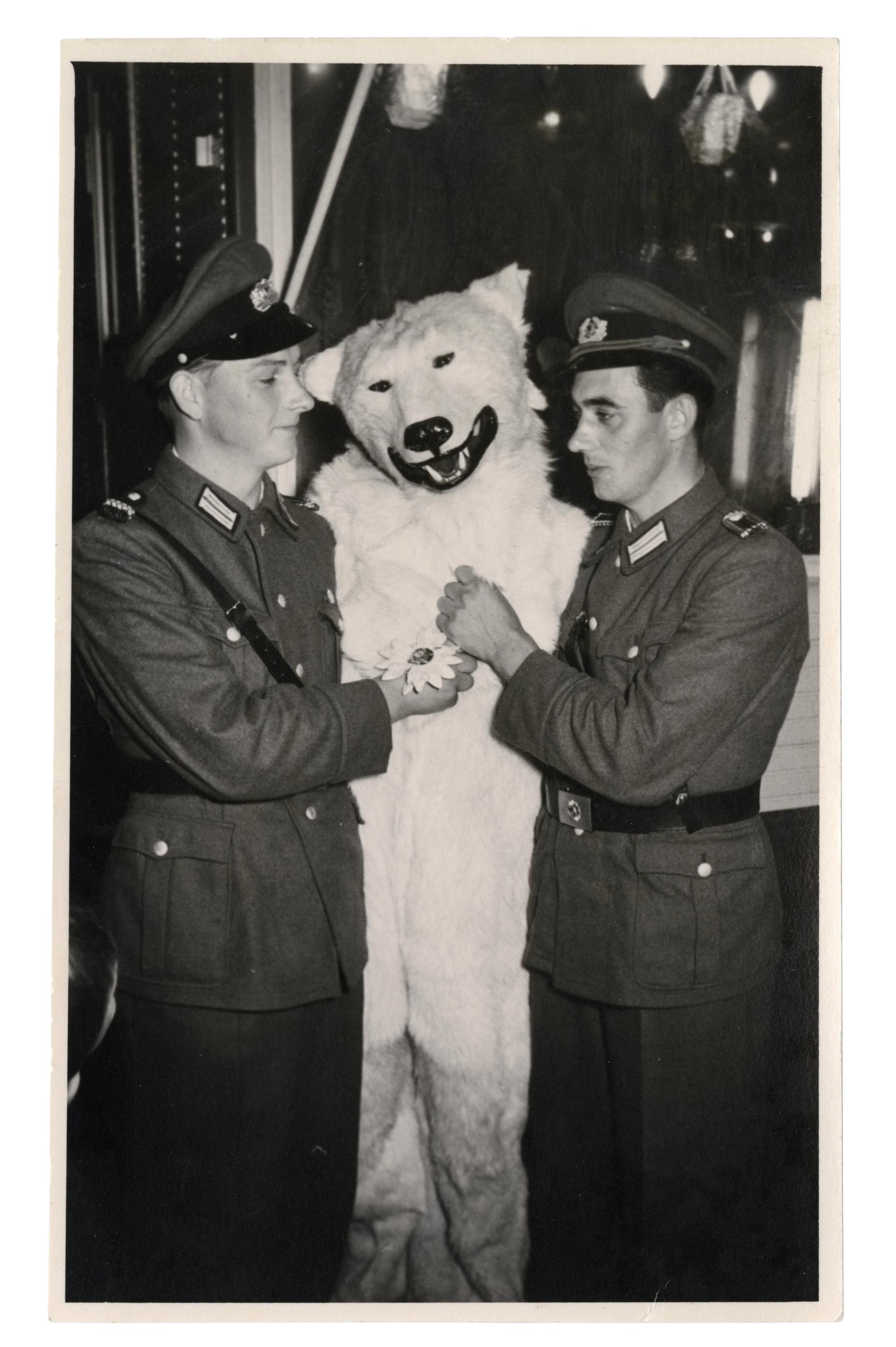 A smiling polar bear sandwiched between two German soldiers in Wehrmacht uniforms.