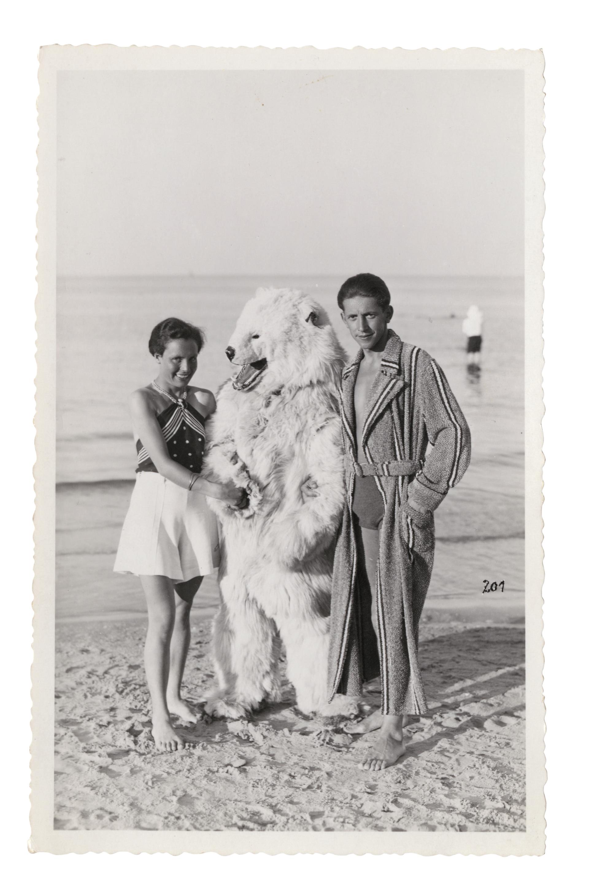 A man in a polar bear suit poses with a young German couple