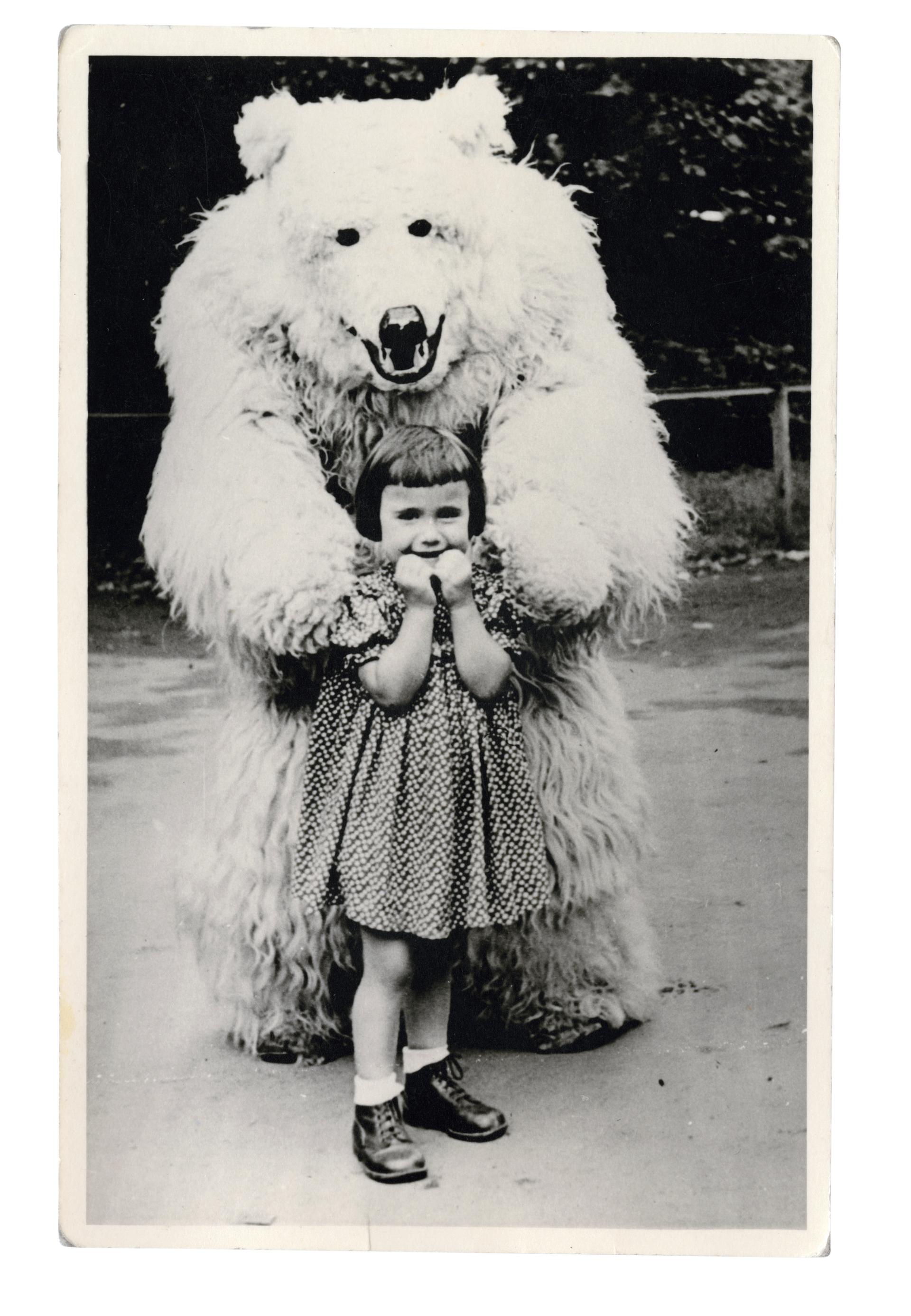 A young German girl stands with a man in a polar bear costume