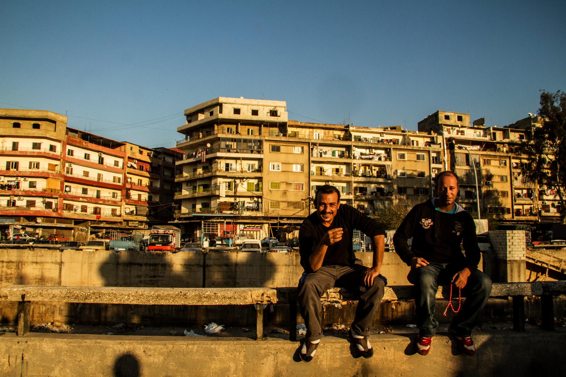Bab al-Tabbaneh residents Usama and Hussein sit on a railing at the edge of the neighborhood. They say for men like them with families to support there isn't enough work in Tripoli and while they're against extremist groups like the Islamic State, they ca