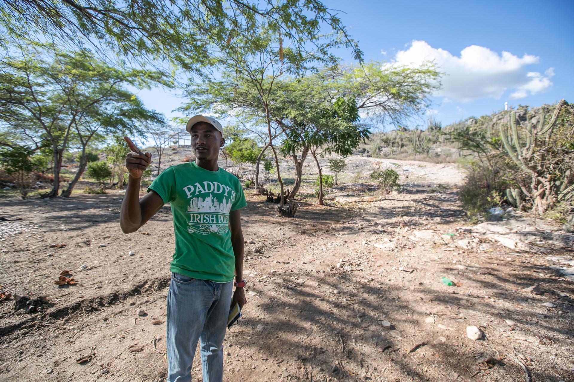 Youth conservation worker Tinio Louis points to the boundary of the 20 square-mile protected iguana habitat in Anse-a-Pitres, Haiti. Project leader Masani Accimé says she's planning to turn the reins over to Louis and other local residents. 