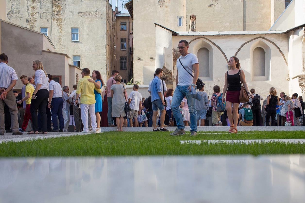 Visitors pass through an open space of grass and polished stone on the former site of the Beth Hamidrash, the study hall adjacent to the Golden Rose synagogue, in Lviv, Ukraine.