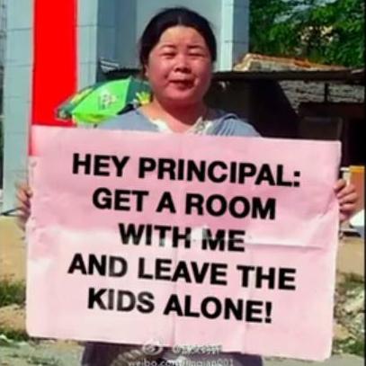 Human rights activist Ye Haiyan, pictured on the southern island of Hainan holding a poster highlighting a string of child-abuse scandals in Chinese schools.