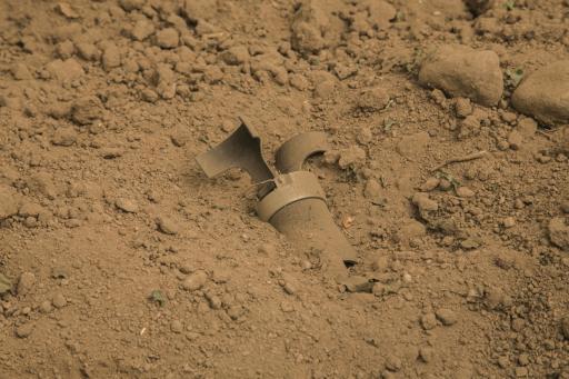 A cluster munition believed to be made in Brazil lies half buried in a cucumber field in Sadaa, Yemen.