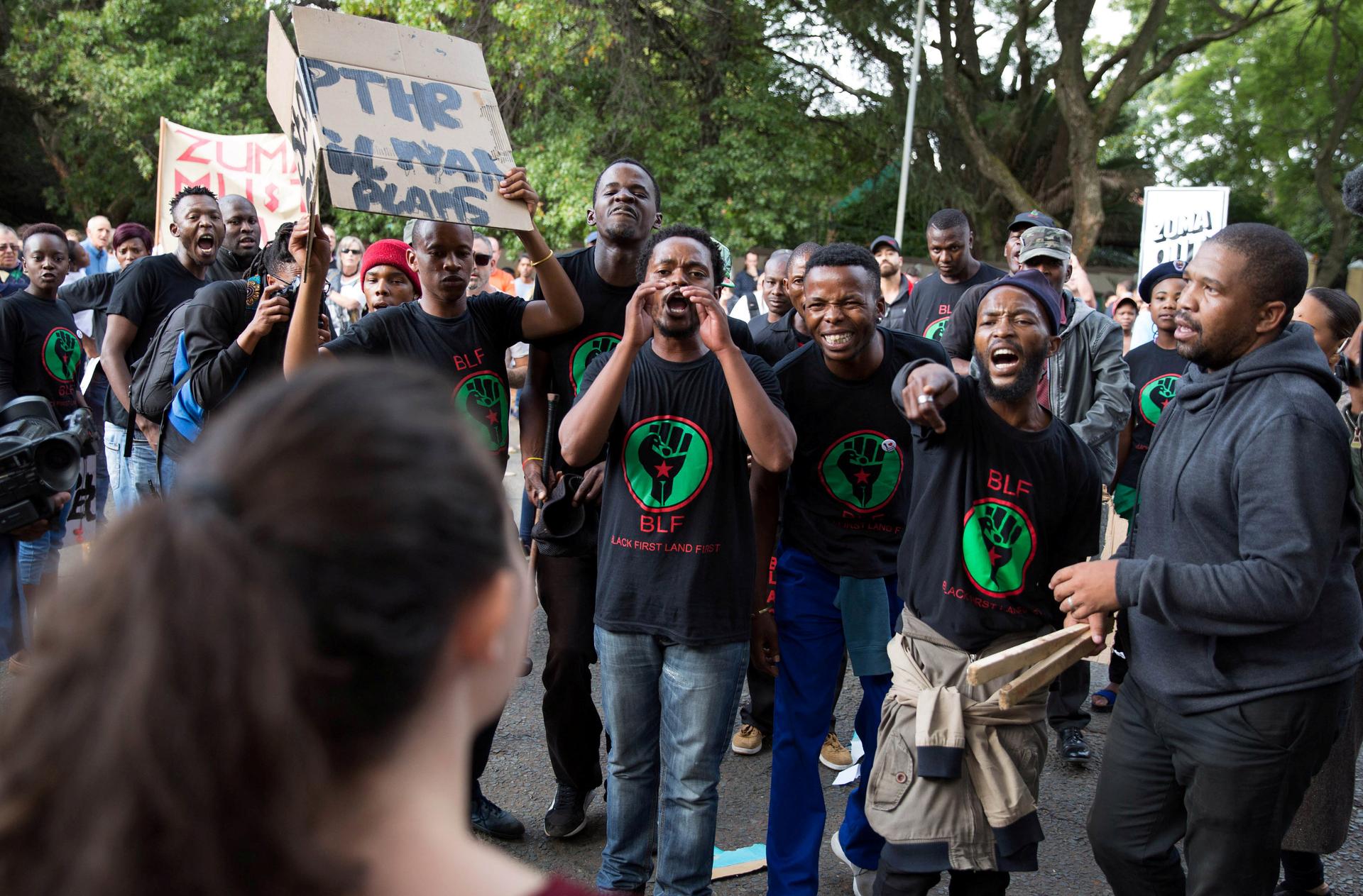 Supporters of President Jacob Zuma confront demonstrators calling for Zuma's removal outside the home of the controversial Gupta family in Johannesburg, South.