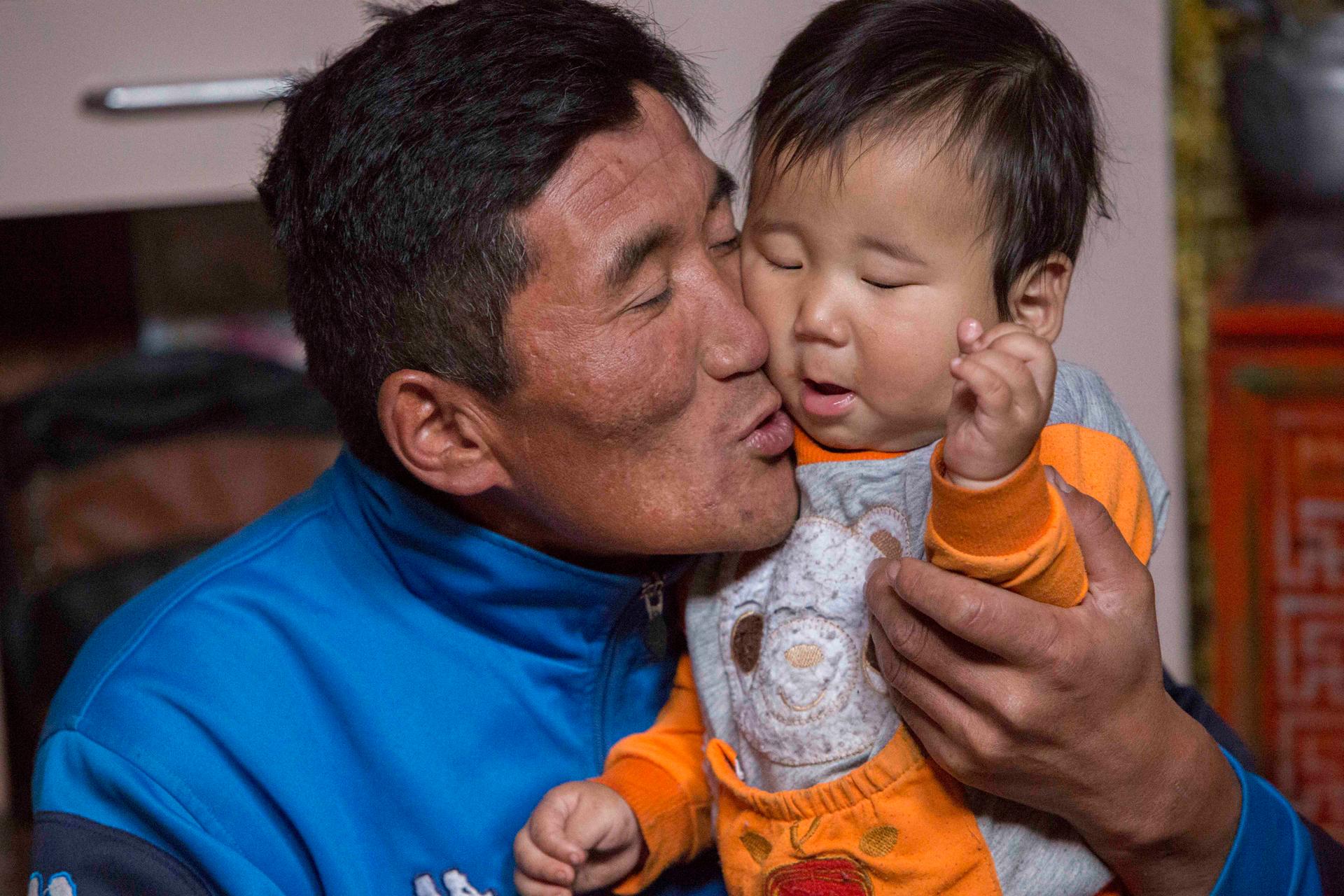 Jargalsaikhan Erdene-Bayar holds his eight-month-old son Munkh-erdene inside his family’s ger in Ulaanbaatar. Erdene-Bayar herded livestock in the countryside until a harsh winter killed most of his animals and forced him to look for work in the city.