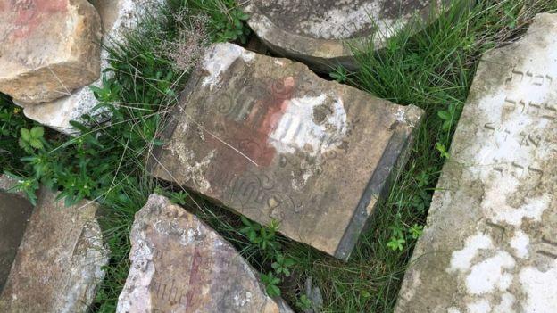 Some of the red crosses that were painted on the headstones in 1943 are still visible.