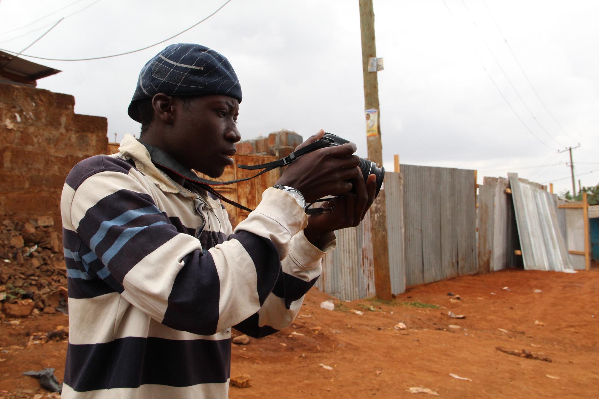 Abbas practices taking pictures with Habari Kibra's only camera. His true passion, though, is making radio.